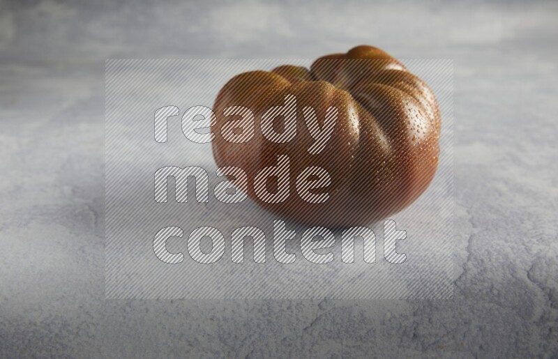 45 degree single heirloom tomato on a light blue textured background