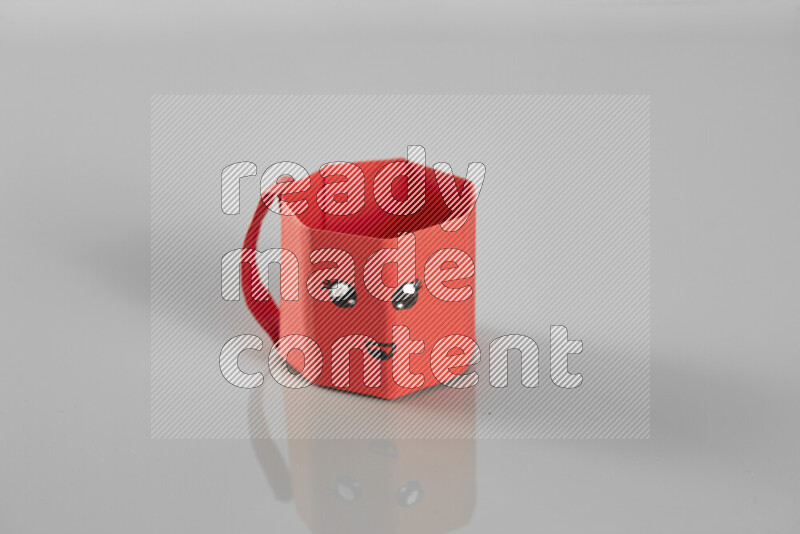 Origami cup on grey background