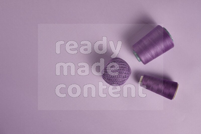 A purple collection of sewing and tailoring tools arranged on a purple background