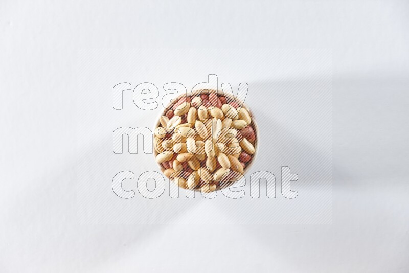 A beige ceramic bowl full of peeled peanuts on a white background in different angles