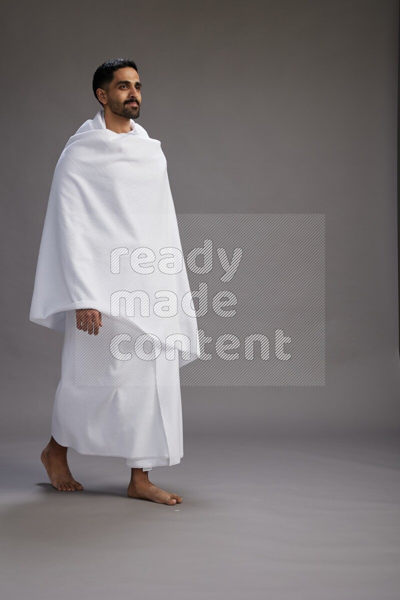 A man wearing Ehram Standing Interacting with the camera on gray background