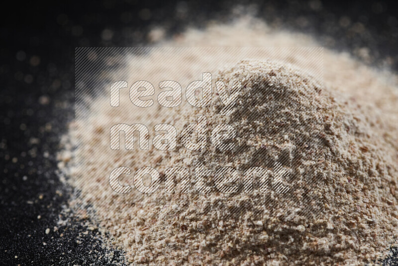 A bunch of onion powder on black background