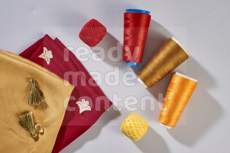 Multicolored fabrics with sewing supplies on grey background