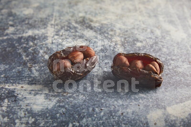 two hazelnuts stuffed madjoul dates on a rustic blue background