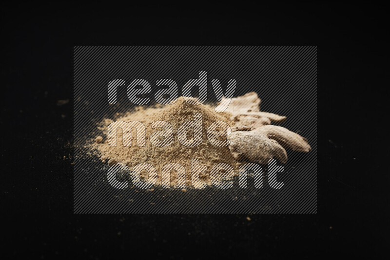 A bunch of ground ginger powder on black background