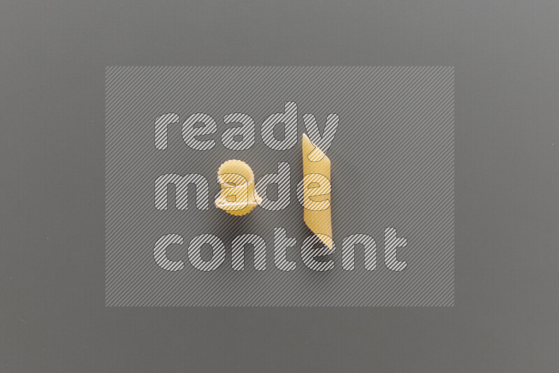 Pipe pasta with other types of pasta on grey background