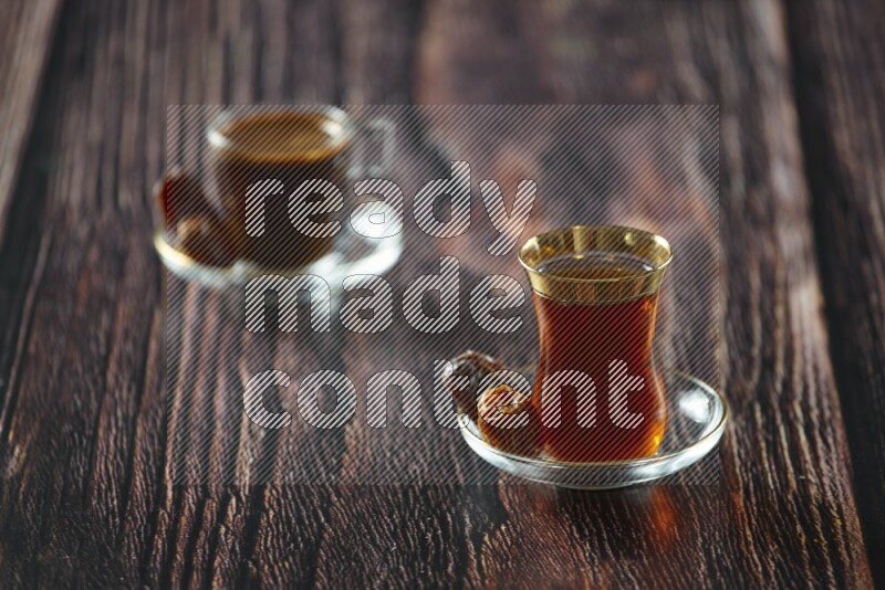 A tea glass cup with dates and coffee on wooden background