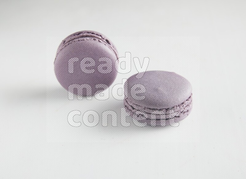 45º Shot of two Purple Blueberry macarons on white background
