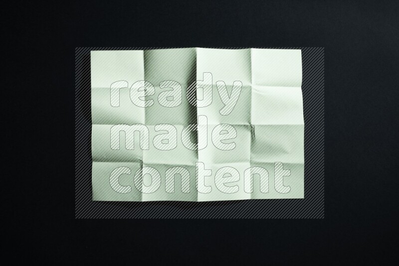 Green paper sheet on black background