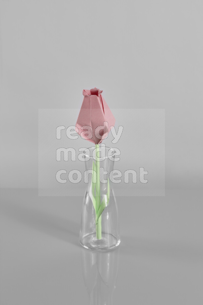 Origami flower on grey background