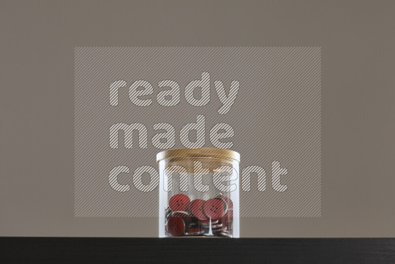 أزرار متنوعة في وعاء زجاجي علي خلفية سوداء