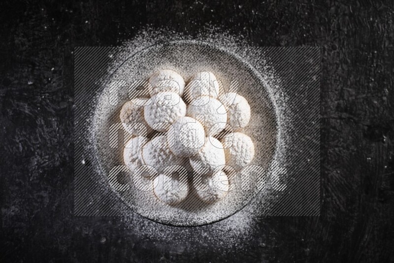 Kahk on a serving plate on a black background