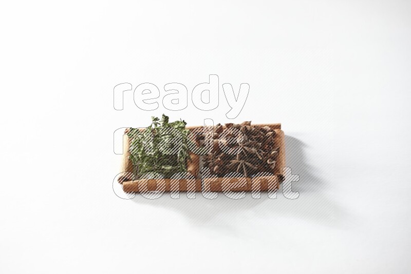 2 squares of cinnamon sticks full of star anise and dried mint leaves on white flooring
