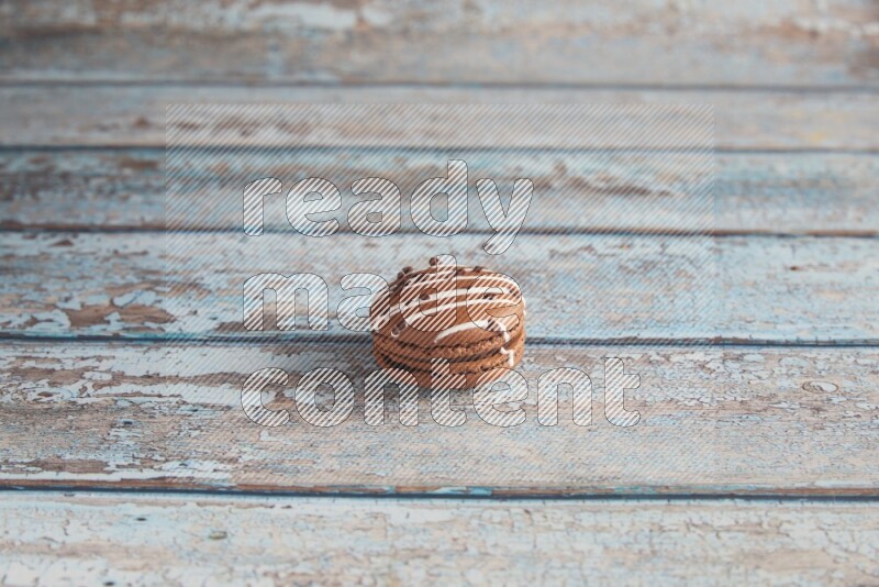 45º Shot of Brown white Chocolate Caramel macaron on light blue wooden background
