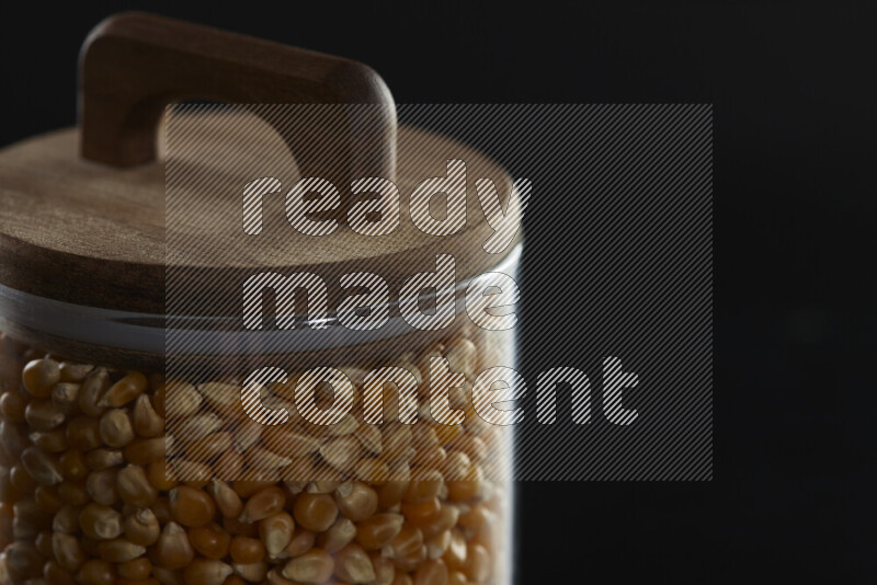 Pop corn in a glass jar on black background