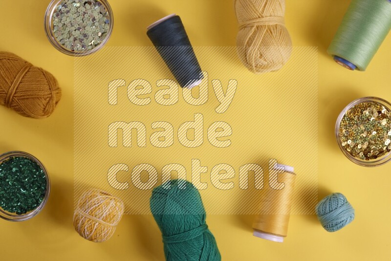 مجموعة من أدوات الخياطة والتفصيل خضراء اللون على خلفية صفراء