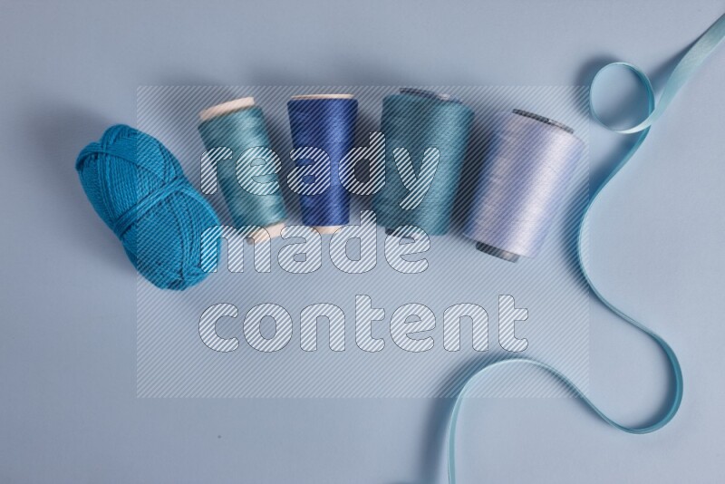 A blue collection of sewing and tailoring tools arranged on a blue background