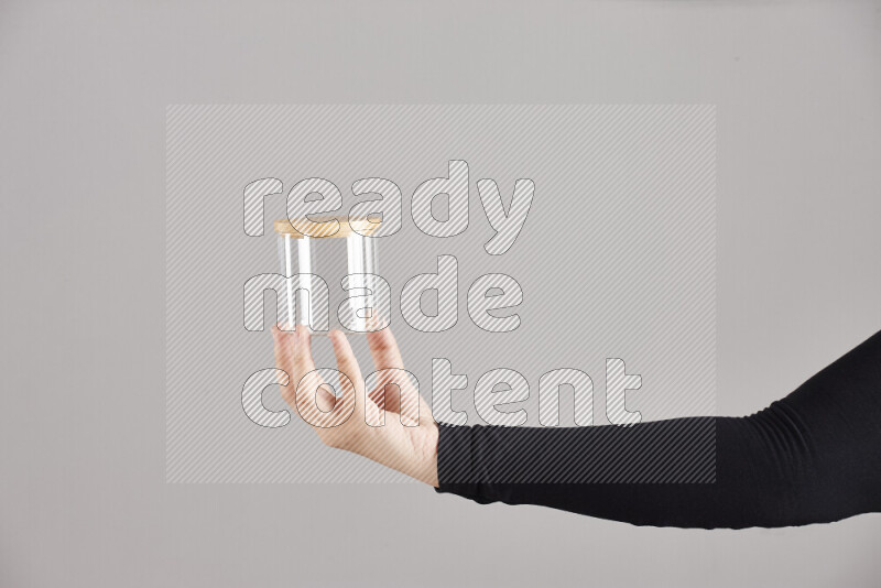 A woman in black abaya holding different glassware in different positions