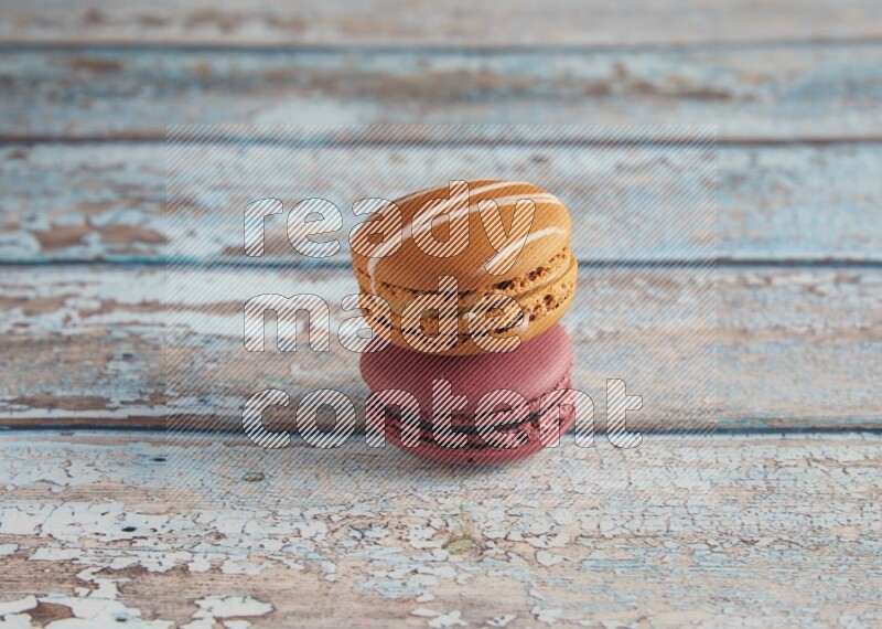 45º Shot of of two assorted Brown Irish Cream, and Red Cherry macarons  on light blue background