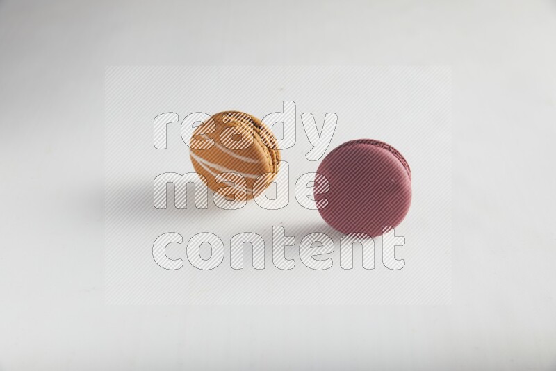 45º Shot of of two assorted Brown Irish Cream, and Red Cherry macarons on white background
