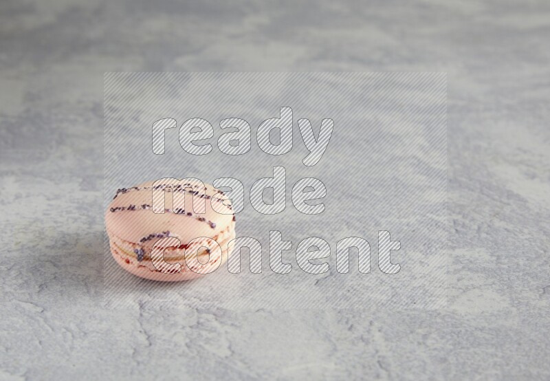 45º Shot of pink orange blossom macaron on white  marble background