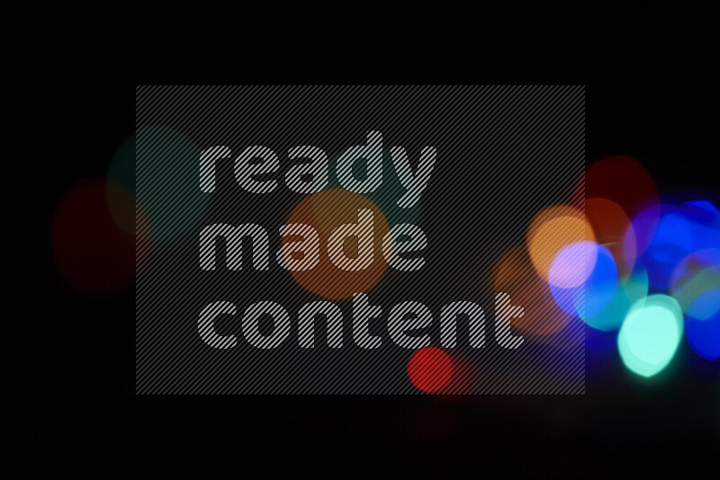 Light bulbs glowing against backdrop of multicolord bokeh