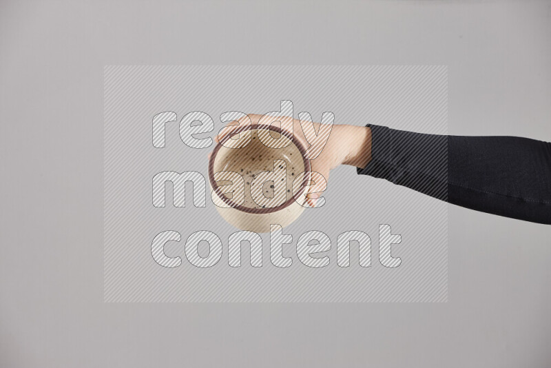 A woman in black abaya holding different pottery essentials in different positions