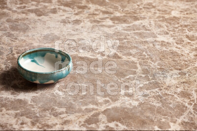 A multicolored pottery plate on beige marble background