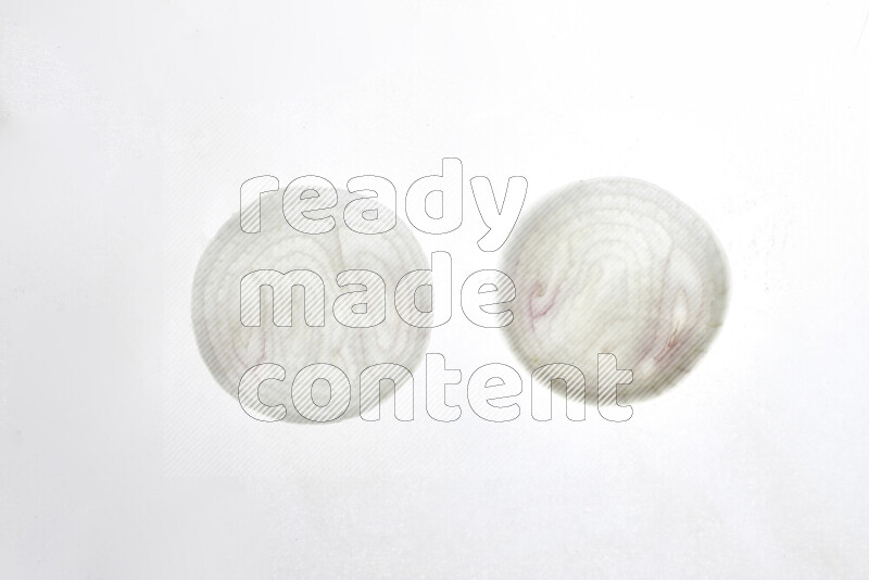 Onion slices on illuminated white background