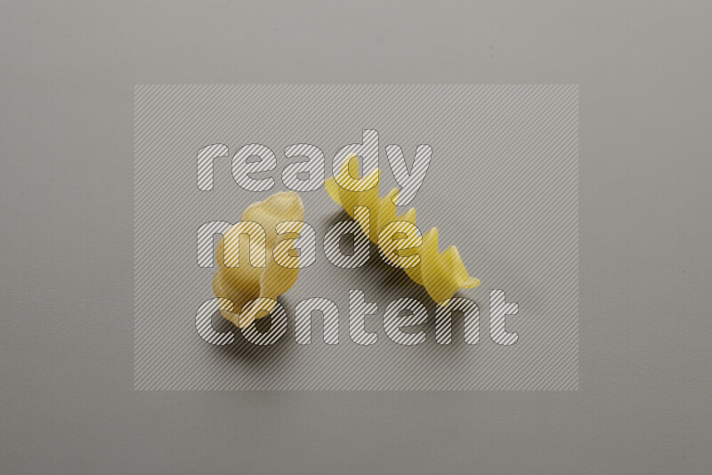 Snails pasta with other types of pasta on grey background