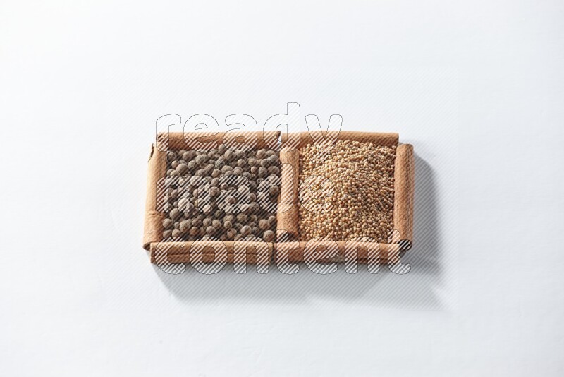 2 squares of cinnamon sticks full of mustard seeds and allspice on white flooring