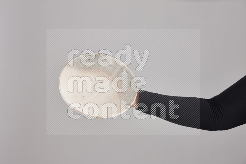 A woman in black abaya holding different pottery essentials in different positions