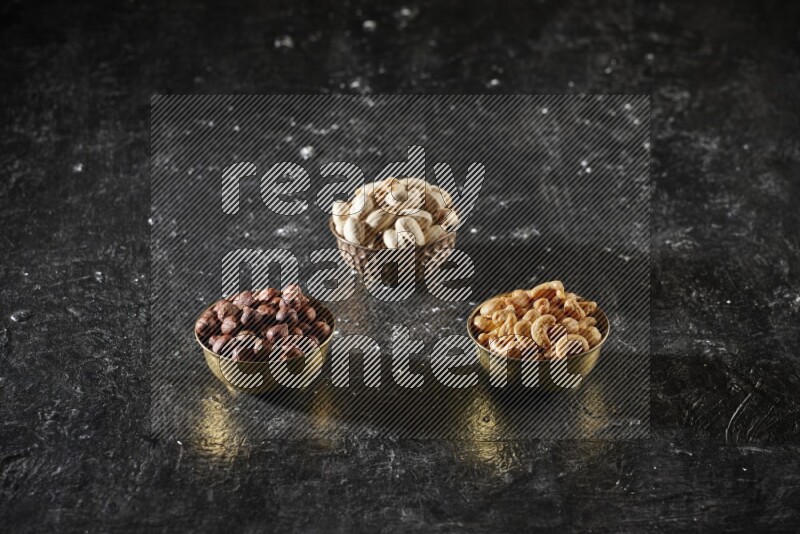 Nuts in a metal bowl in a dark setup