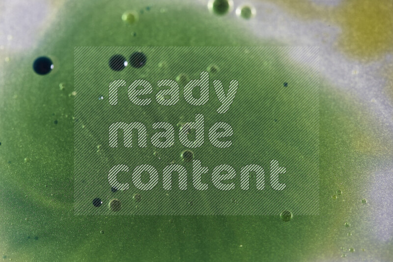 لقطات مقربة لقطرات ألوان مائية صفراء وزرقاء وخضراء على سطح الزيت على خلفية بيضاء