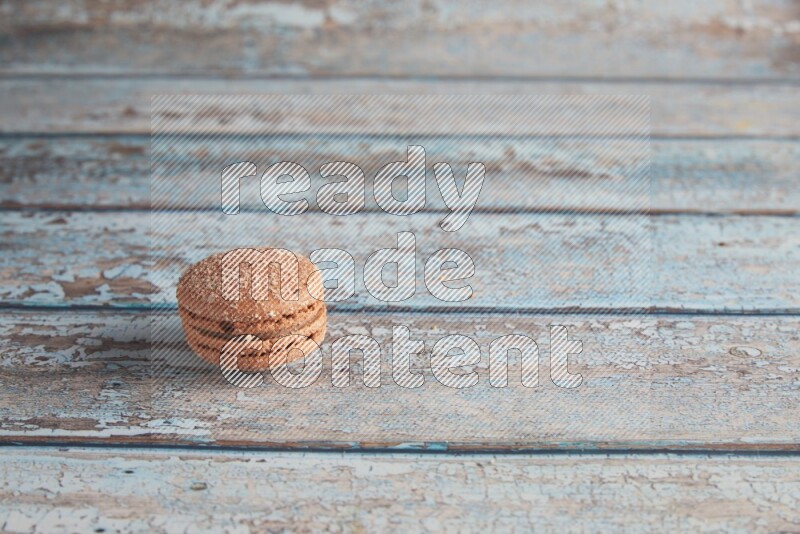 45º Shot of Brown Hazelnuts macaron on light blue wooden background