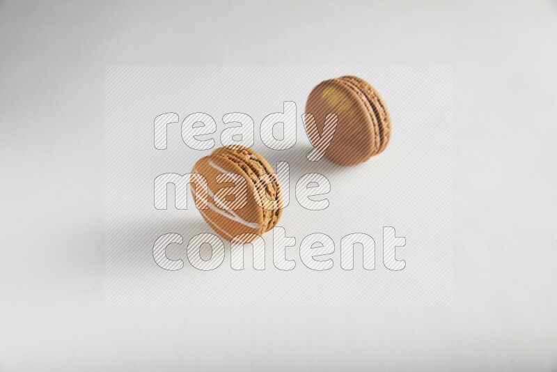 45º Shot of of two assorted Brown Irish Cream, and Brown Coffee macarons  on white background