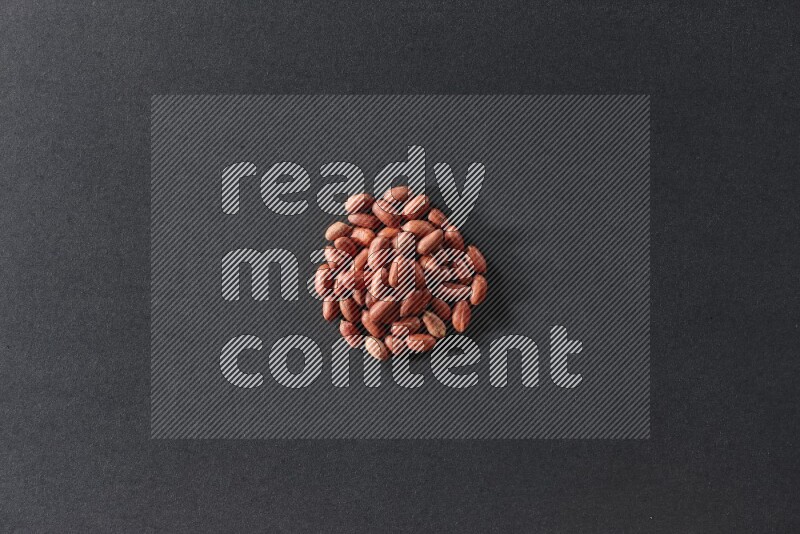 A bunch of red skin peanuts on a black background in different angles