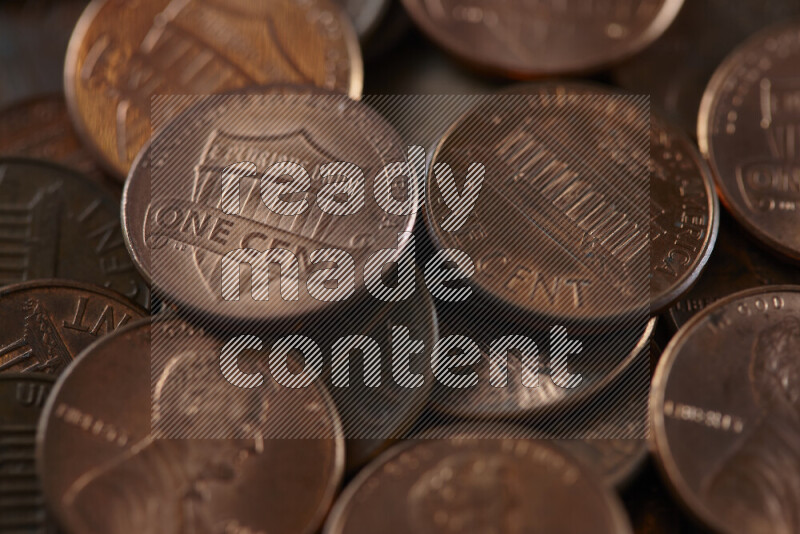 A close-up of scattered United States one cent coins on grey background