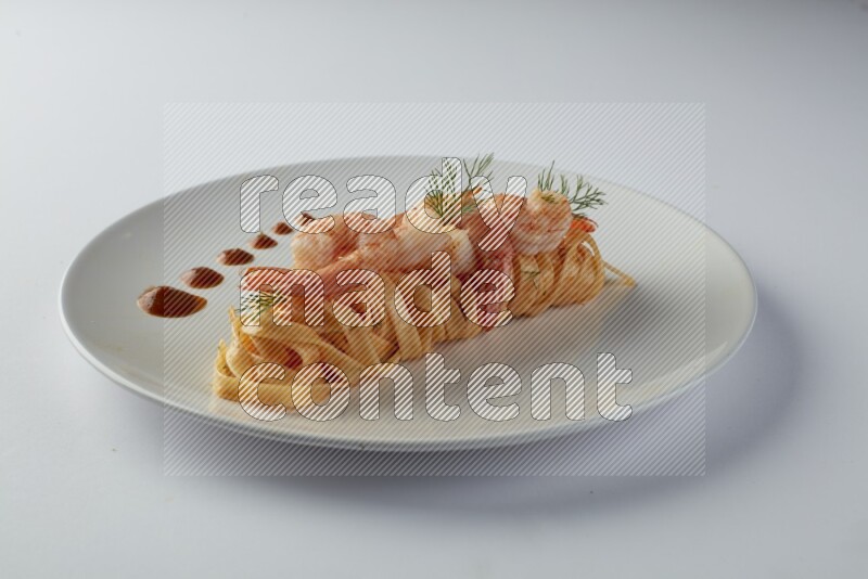 Fettuccini red sauce pasta with shrimp in a white plate on a white background
