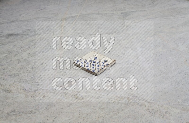Top view shot of a pottery coaster\ tile on beige marble flooring
