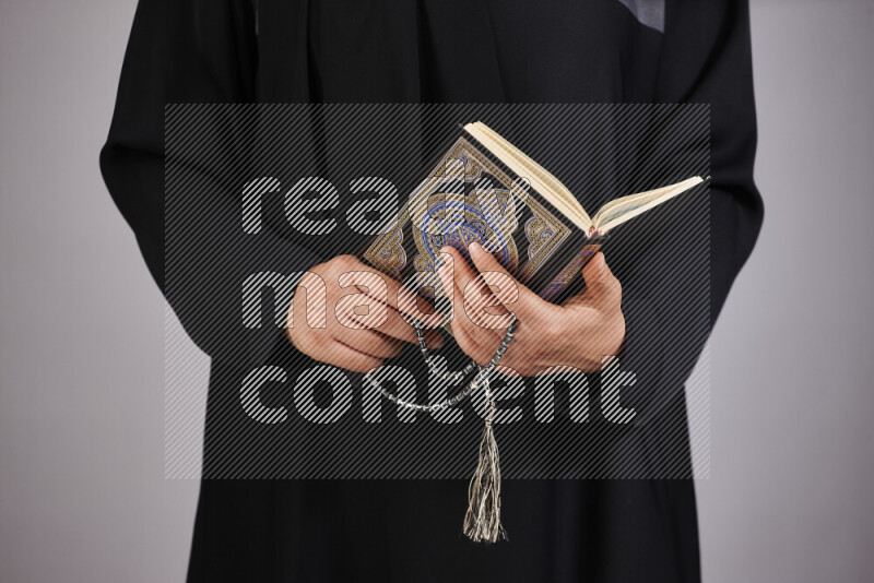 امرأة تحمل بيديها مصحف القرآن في أوضاع متعددة