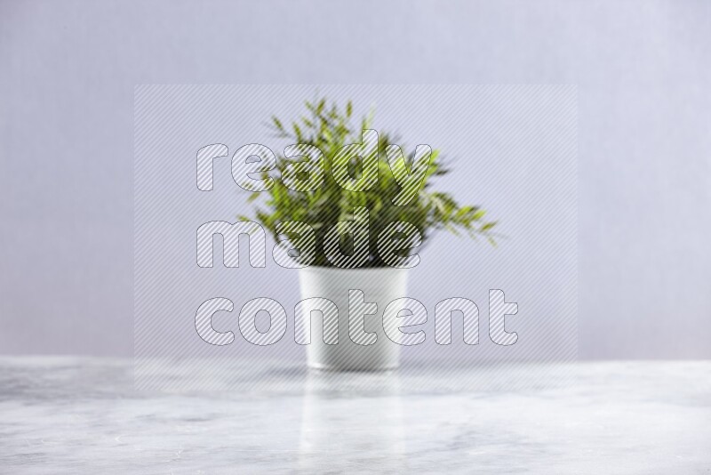 Artificial plant in white pot on grey marble background