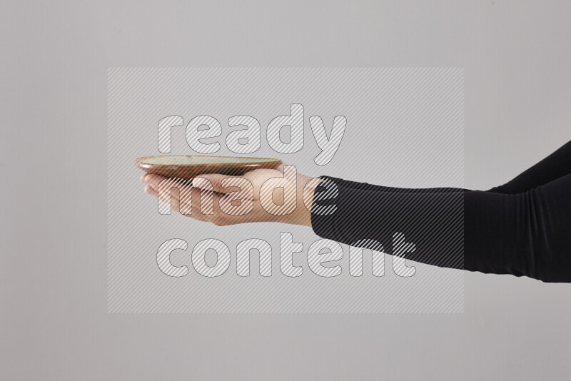 امرأة ترتدي عباءة سوداء تحمل أدوات فخارية مختلفة في أوضاع متعددة