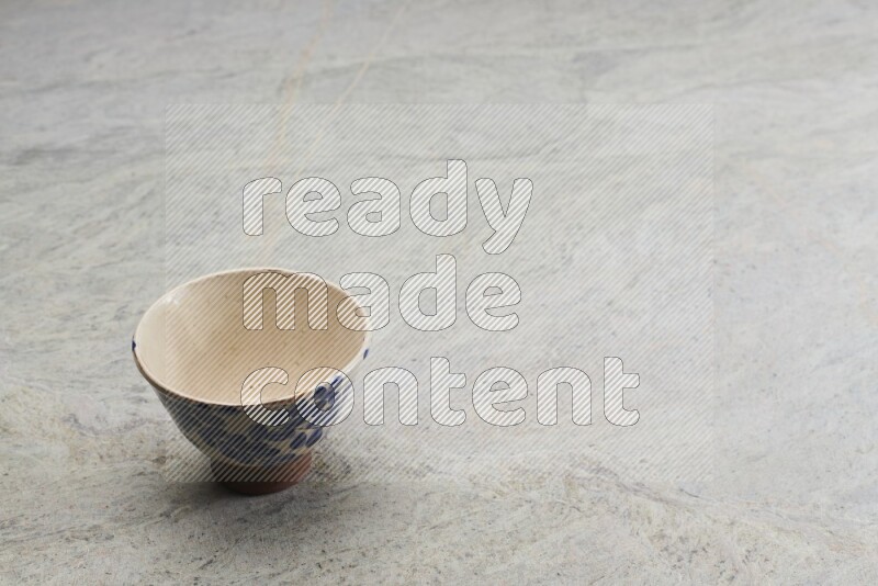 A multicolored pottery bowl on grey marble background