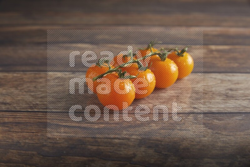 Orange cherry tomato vein on a textured wooden background 45 degree