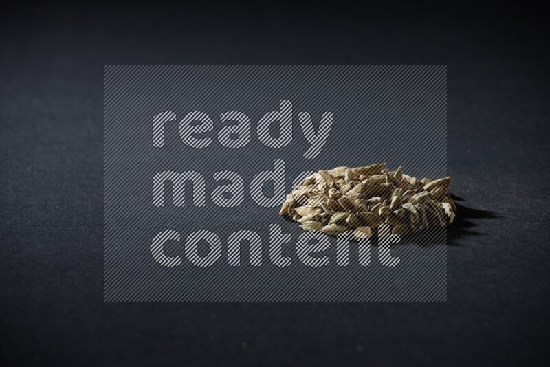 Cardamom in a circle shape on black flooring