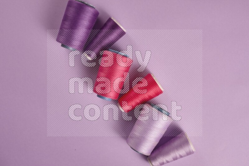 A pink and purple collection of sewing and tailoring tools arranged on a purple background