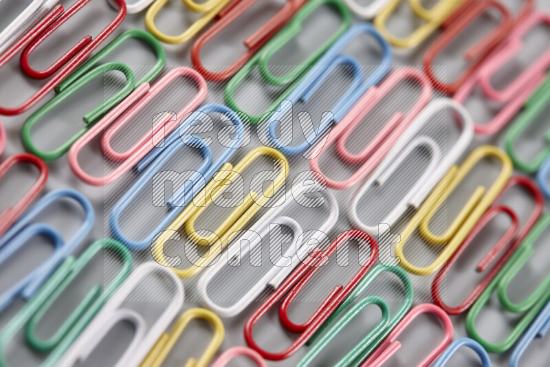 Multicolored paper clips isolated on a grey background