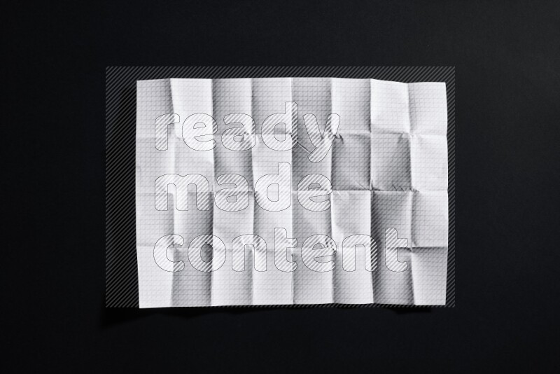 Folded notebook sheet on black background