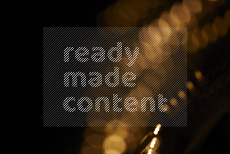 Light bulbs glowing against backdrop of golden bokeh